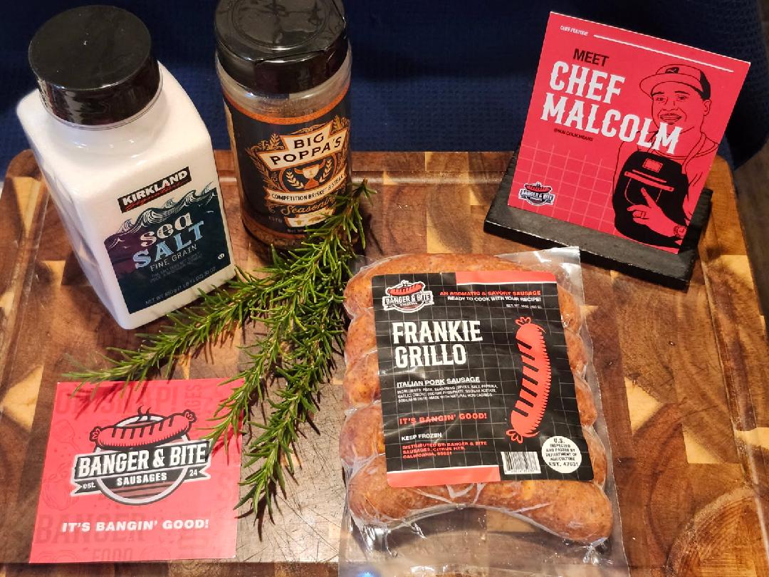 Cutting board display showcasing seasonings, a postcard with an illustrator of the owner, Malcolm, a square thank you card, and a "Frankie Grillo" sausage pack