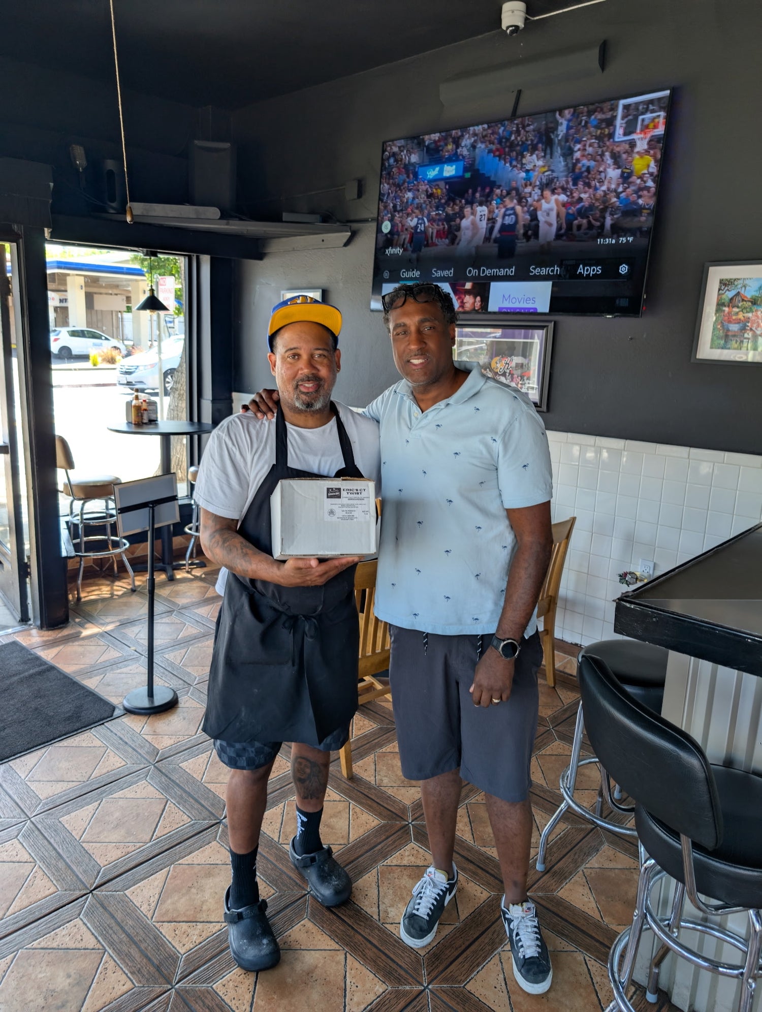 Our founder, Malcolm, standing next to the owner of Creole Soul Restaurant & Bar, who is holding one of our packages
