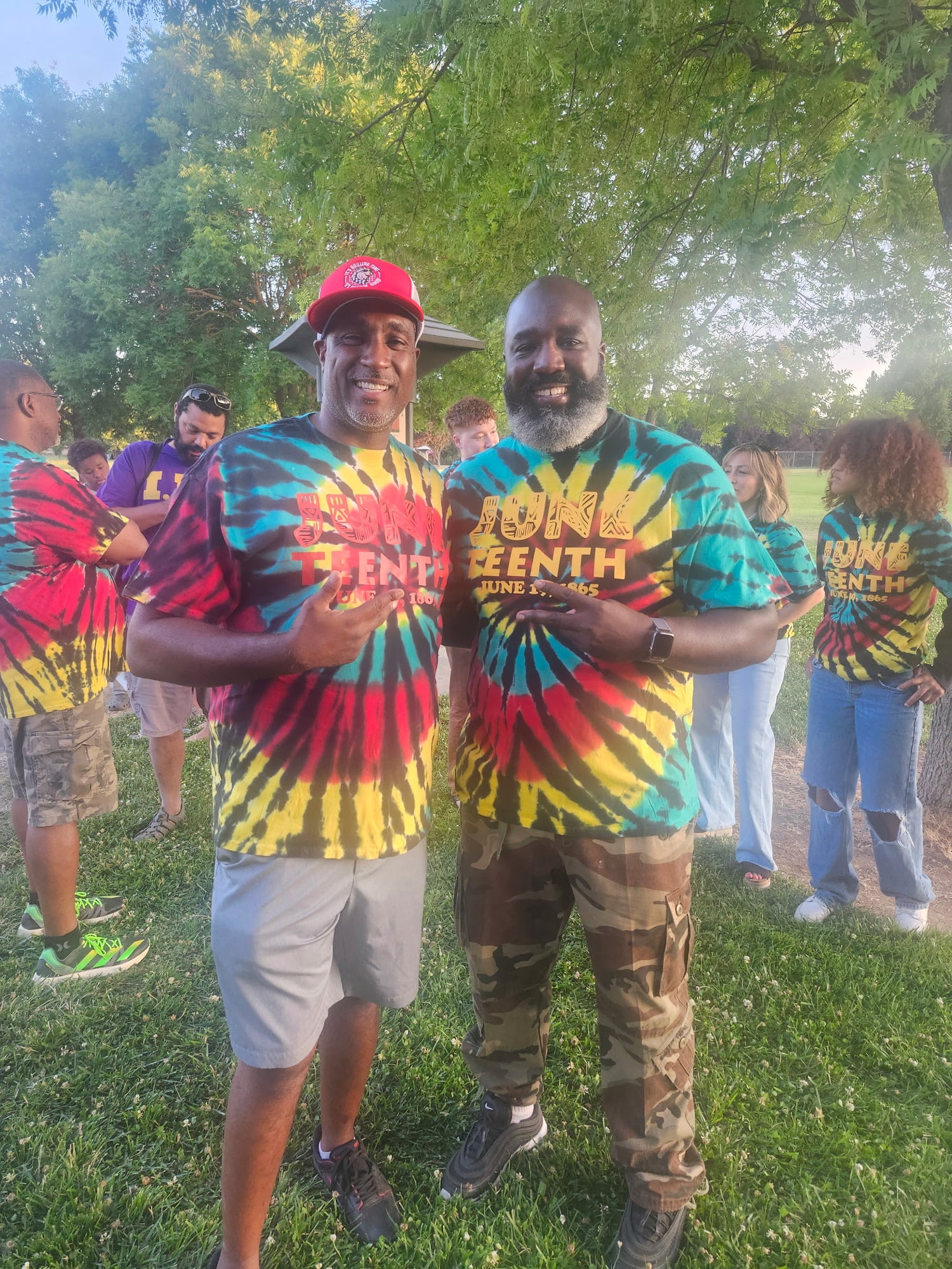 Our founder, Malcolm, standing next to friend and vendor, wearing tie-dye shirts in the outdoors Juneteenth event