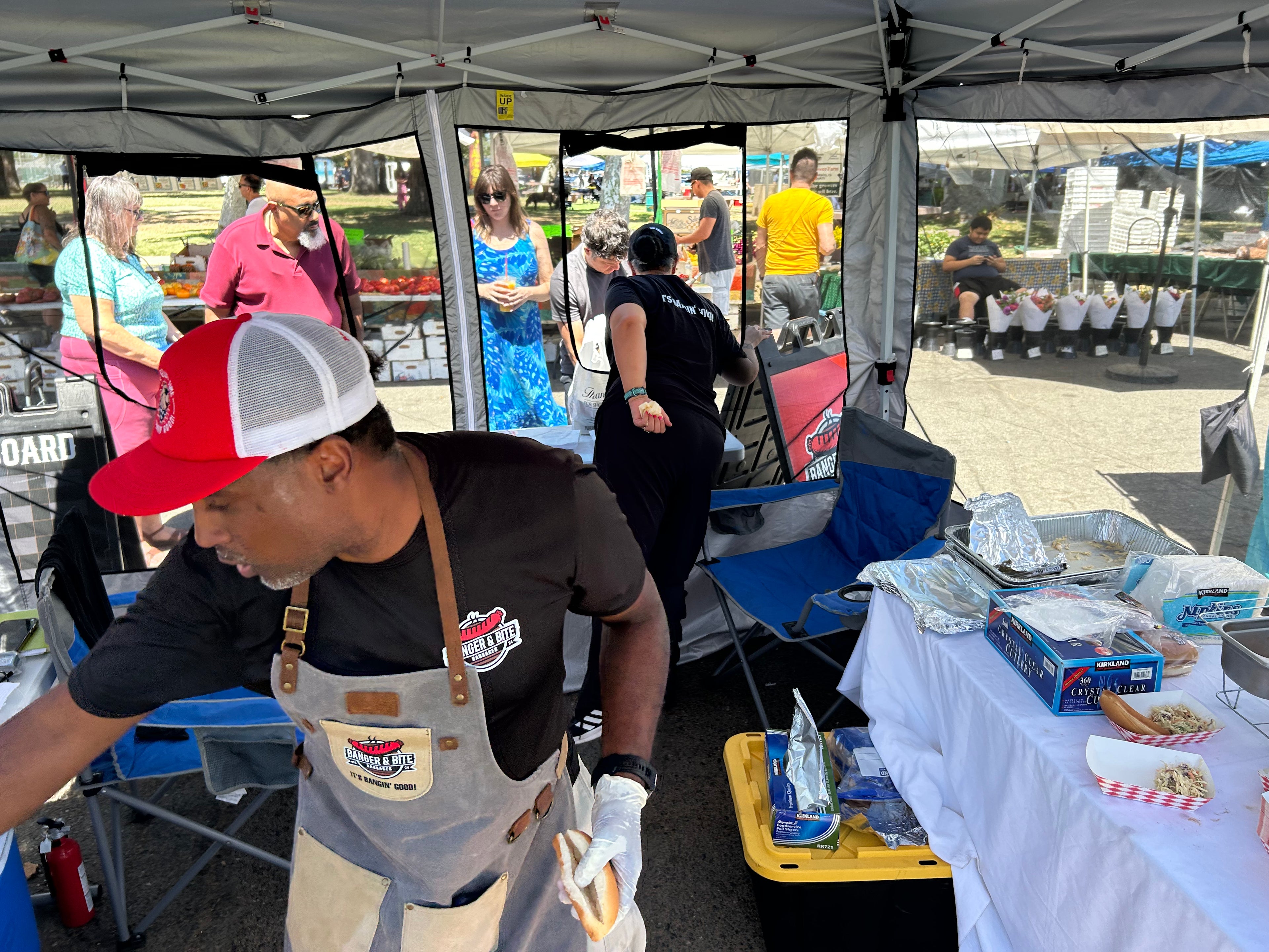 Our founder, Malcolm, in his Banger & Bite branded apron and cap serving up some sausages at a local farmer's market